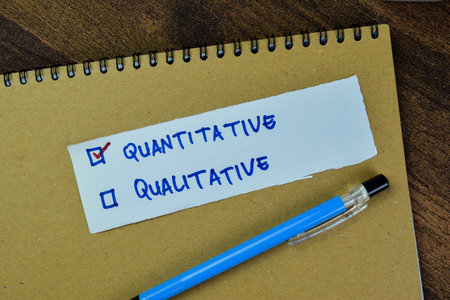 Concept of Quantitative and Qualitative write on sticky notes isolated on Wooden Table.の写真素材