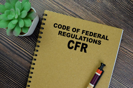 Concept of CFR - Code of Federal Regulations write on book isolated on Wooden Table.