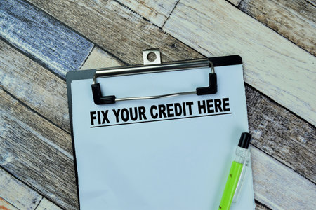 Concept of Fix Your Credit Here write on paperwork isolated on Wooden Table.の写真素材