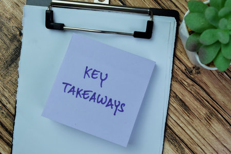 Concept of Key Takeaways write on sticky notes isolated on Wooden Table.