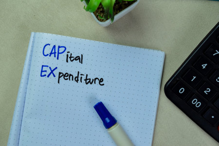 Concept of CAPEX - Capital Expenditure write on book isolated on Wooden Table.の写真素材