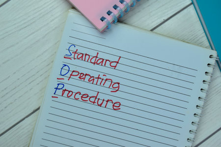 Concept of SOP - Standrad Operating Procedure write on book isolated on Wooden Table.の写真素材
