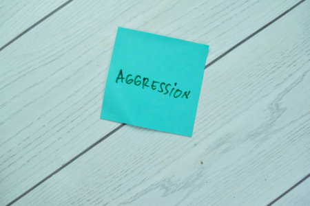 Concept of Aggression write on sticky notes isolated on Wooden Table.の写真素材