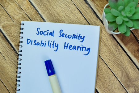 Concept of Social Security Disability Hearing write on book isolated on Wooden Table.の写真素材