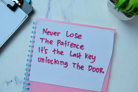 Concept of Never Lose The Patience It's The Last Key Unlocking The Door write on sticky notes isolated on Wooden Table.の写真素材