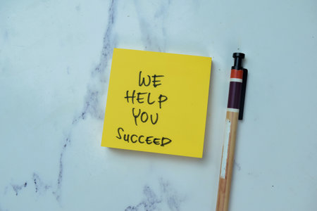 Concept of We Help You Succeed write on sticky notes isolated on Wooden Table.の写真素材