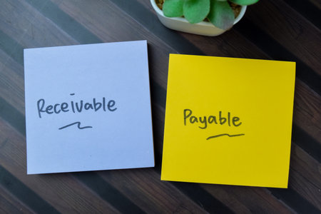 Concept of Receivable Payable write on sticky notes isolated on Wooden Table.