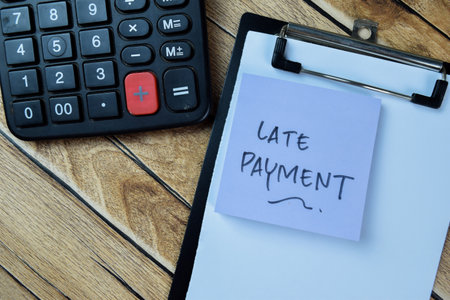 Concept of Late Payment write on sticky notes isolated on Wooden Table.の写真素材