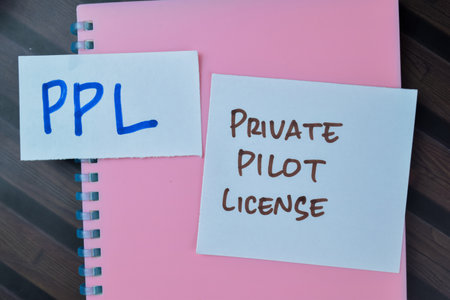 Concept of PPL - Private Pilot License write on sticky notes isolated on Wooden Table.の写真素材