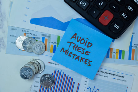 Concept of Avoid These Mistakes write on sticky notes with Indonesian Currency isolated on Wooden Table.の写真素材