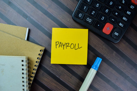 Concept of Payroll write on sticky notes isolated on Wooden Table.の写真素材