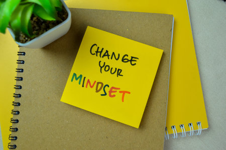 Concept of Change Your Mindset write on sticky notes isolated on Wooden Table.の写真素材