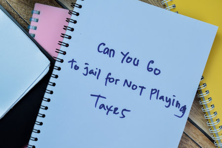 Concept of Can You Go To Jail For Not Playing Taxes write on book isolated on Wooden Table.の写真素材
