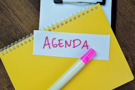 Concept of Agenda write on sticky notes isolated on Wooden Table.の写真素材