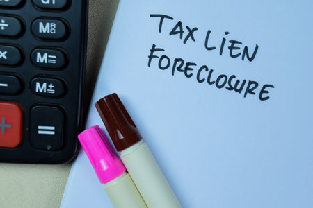Concept of Tax Lien Foreclosure write on book isolated on Wooden Table.の写真素材