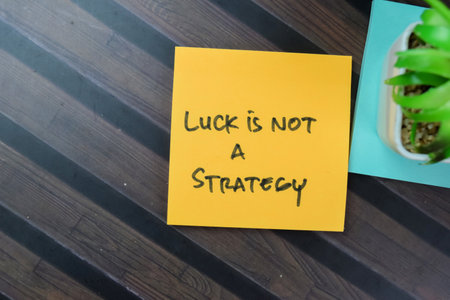 Concept of Luck Is Not A Strategy write on sticky notes isolated on Wooden Table.の写真素材