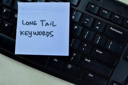 Concept of Long Tail Keywords write on sticky notes isolated on Wooden Table.