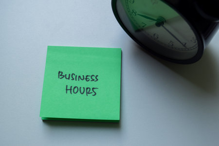 Concept of Business Hours write on sticky notes isolated on Wooden Table.の写真素材