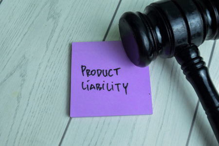 Concept of Product Liability write on sticky notes with gavel isolated on Wooden Table.の写真素材