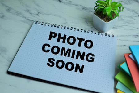 Concept of Photo Coming Soon write on book isolated on Wooden Table.の写真素材