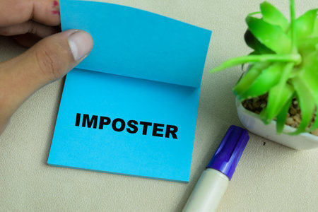 Concept of Imposter write on sticky notes isolated on Wooden Table.の写真素材