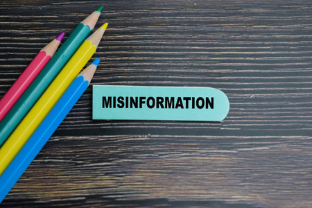 Concept of Misinformation write on sticky notes isolated on Wooden Table.の写真素材