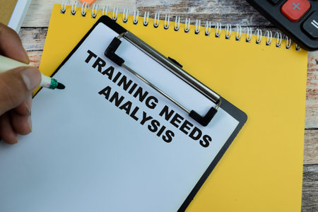 Concept of Training Needs Analysis write on paperwork isolated on wooden background.