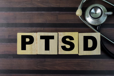 Concept of The wooden Cubes with the word PTSD on wooden background.の写真素材