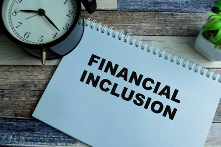 Concept of Financial Inclusion write on book isolated on Wooden Table.の写真素材