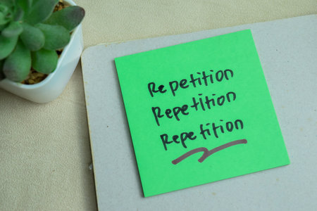Concept of Repetition, Repetition, Repetition write on sticky notes isolated on Wooden Table.の写真素材