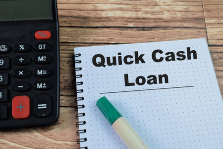 Concept of Quick Cash Loan write on book isolated on Wooden Table.の写真素材