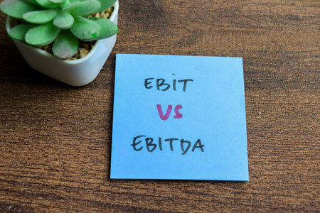 Concept of Ebit vs Ebitda write on sticky notes isolated on Wooden Table.の写真素材