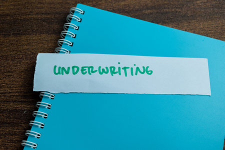 Concept of Underwriting write on sticky notes isolated on Wooden Table.の写真素材