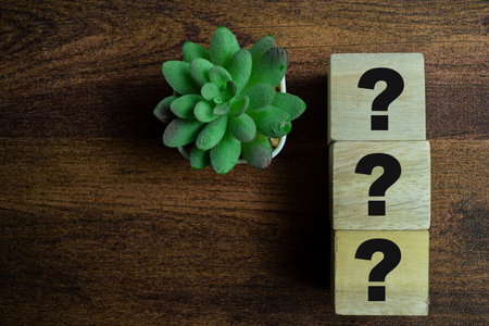 Concept of The wooden Cubes with the word Three question marks on wooden background.