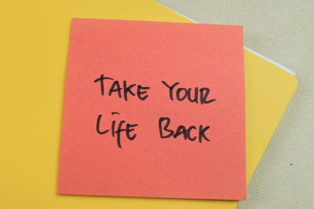 Concept of Take Your Life Back write on sticky notes isolated on Wooden Table.
