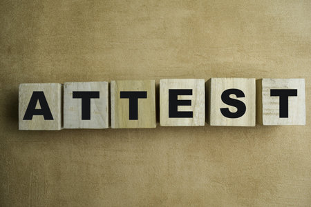 Concept of The wooden Cubes with the word Attest on wooden background.