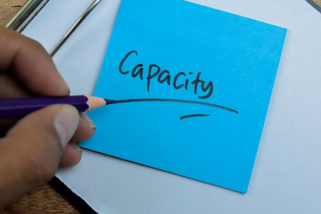 Concept of Capacity write on sticky notes isolated on Wooden Table.