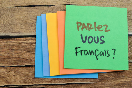 Concept of Parlez Vous Francais in Language write on sticky notes isolated on Wooden Table.