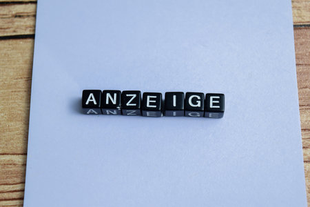 Concept of The wooden Cubes with the word Anzeige it means Advertisement on wooden background. German language isolated on Wooden Table.の写真素材