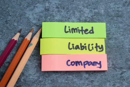 Concept of Limited Liability Company write on sticky notes isolated on Wooden Table.の写真素材
