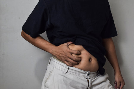 A man having stomachache on beige background
