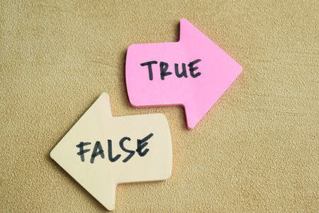 Concept of False or True write on sticky notes isolated on Wooden Table.の写真素材