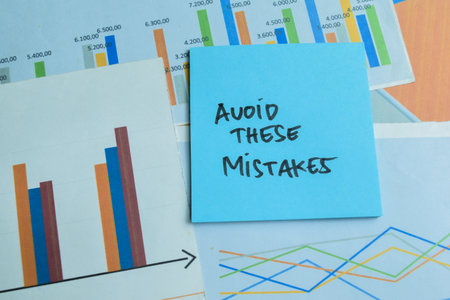 Concept of Avoid These Mistakes write on sticky notes isolated on Wooden Table.