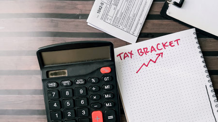 Concept of Tax Bracket write on book isolated on Wooden Table.の写真素材