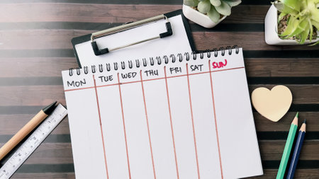 Concept of Weekly Calendar write on book isolated on Wooden Table.の写真素材