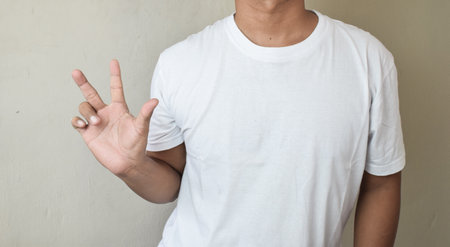 A man in casual clothes showing three fingers while counting