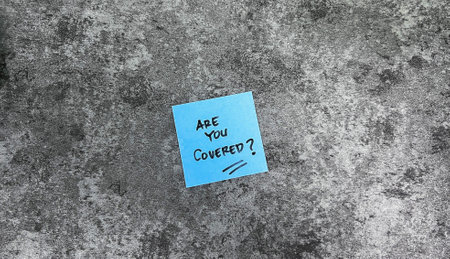 Concept of Are You Covered? write on sticky notes isolated on Wooden Table.