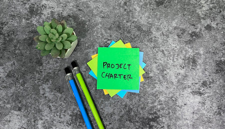 Concept of Project Charter write on sticky notes isolated on Wooden Table.の写真素材