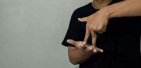 young man showing stand gesture in sign language to communicateの写真素材