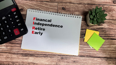 Concept of FIRE - Financial Independence Retire Early write on book isolated on Wooden Table.の写真素材